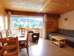 salon ze stołem i dużym oknem w obiekcie Les Gets - Appartement 59m², 2 chambres, proche centre et pistes, animaux acceptés, parking - FR-1-623-327 w mieście Les Gets