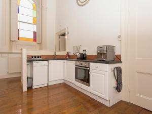 een keuken met witte kasten en een wastafel bij The Music Room in Aveton Gifford