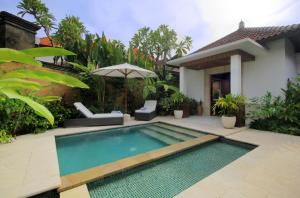 a swimming pool in front of a villa at Sagara Villas and Suites Sanur in Sanur