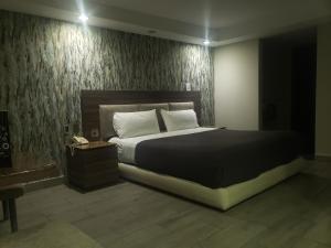 Motel Nuevo Tijuana في مدينة ميكسيكو: غرفة نوم بسرير كبير وهاتف
