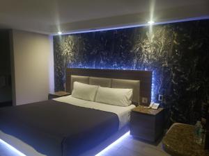 Motel Nuevo Tijuana في مدينة ميكسيكو: غرفة نوم بسرير وجدار بالنباتات