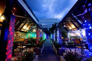 a garden with colorful lights on a building at Hotel Maximillian in Tanjung Balai Karimun