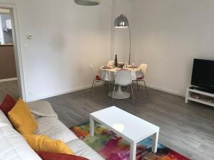 een woonkamer met een witte bank en een tafel bij Le Johannes-Colmar centre historique in Colmar