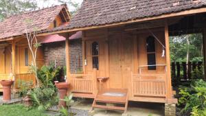 a small wooden house with a bench in front of it at Omah Rumba Bata in Ngemplak +19 photos