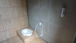 a bathroom with a shower with a toilet in it at Omah Rumba Bata in Ngemplak