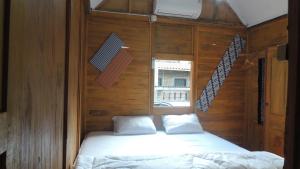 ein Schlafzimmer mit einem Bett in einer Holzwand in der Unterkunft Omah Rumba Bata in Ngemplak