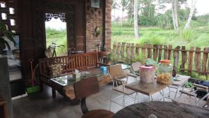 eine Terrasse mit einem Tisch, Stühlen und einem Zaun in der Unterkunft Omah Rumba Bata in Ngemplak