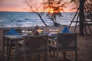 un tavolo e sedie sulla spiaggia con l'oceano di Golden Lotus Homestay a Phu Quoc