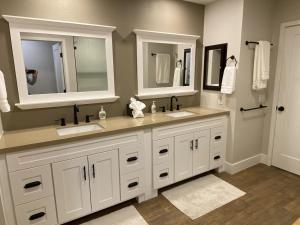 a bathroom with two sinks and two mirrors at Upscale Palm Valley Condo-Acrisure Arena 4mi-El Paseo 6mi-Club Privileges Golf, Tennis, Pickleball in Palm Desert