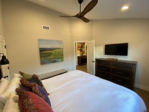 a bedroom with a bed and a flat screen tv at Upscale Palm Valley Condo-Acrisure Arena 4mi-El Paseo 6mi-Club Privileges Golf, Tennis, Pickleball in Palm Desert