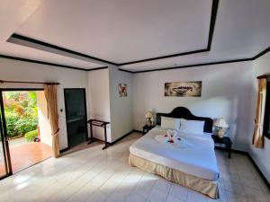 a bedroom with a bed with a flower on it at Jasmin Resort - SHA Plus in Khao Lak