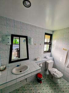 a bathroom with a sink and a toilet and a mirror at Jasmin Resort - SHA Plus in Khao Lak