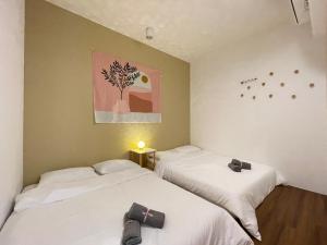 two beds in a room with a painting on the wall at INS Home at Midhills Genting Highlands Free WiFi in Bentong +78 photos