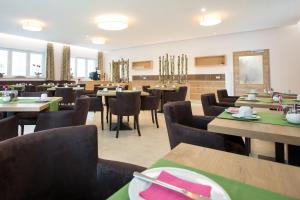 uma sala de jantar com mesas e cadeiras num restaurante em Hotel Bauer garni em Ingolstadt