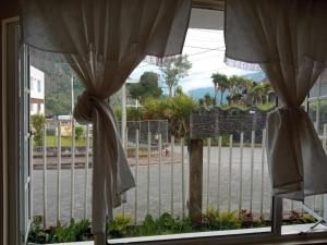 una ventana con cortinas y vistas a la calle en Graces Hospedaje, en Baños