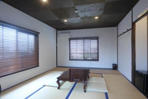 una habitación con una mesa en el medio de una habitación en 淡路島西海岸の宿 梅木屋 en Sumoto