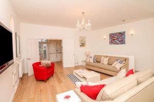 a living room with a couch and a red chair at 10 Cove View in Ilfracombe