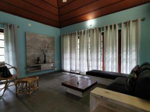 uma sala de estar com um sofá e uma mesa em Afrika House by Afrind Hospitality em Ernakulam