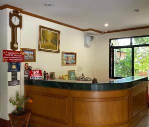 un bar in un ristorante con un orologio sul muro di Kata View Guest House a Kata Beach