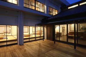 淡路島西海岸の宿 梅木屋 في Sumoto: مبنى فارغ بنوافذ زجاجية وارضية خشبية