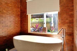 a bath tub in a bathroom with a window at Sagara Villas and Suites Sanur in Sanur