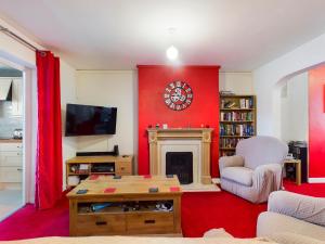 a living room with a fireplace and a red wall at 2BD City Centre Flat nr Anfield Stadium Liverpool in Liverpool