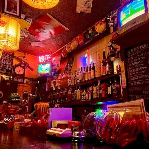 un bar con muchas botellas en la pared en Guest House Kutomare en Kure