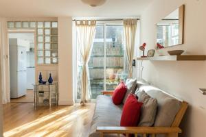 uma sala de estar com um sofá com almofadas vermelhas em Super 1BD Garden Flat Islington London em Londres