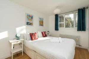 um quarto com uma grande cama branca e uma janela em Super 1BD Garden Flat Islington London em Londres