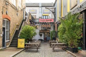 an empty alley with wooden benches in a building at Super 1BD Garden Flat Islington London in London