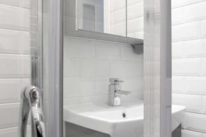 Baño blanco con lavabo y espejo en Beautiful 3BD Flat in Archway London, en Londres