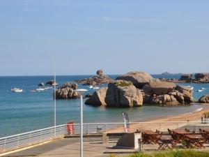 une plage avec bancs et rochers dans l'eau dans l'établissement Appartement Trégastel, 2 pièces, 4 personnes - FR-1-368-127, à Trégastel