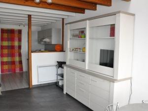 uma cozinha com armários brancos e uma televisão em Appartement Perros-Guirec, 1 pièce, 4 personnes - FR-1-368-75 em Perros-Guirec