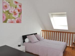 um quarto com uma cama com uma pintura de flores na parede em Appartement Perros-Guirec, 1 pièce, 4 personnes - FR-1-368-75 em Perros-Guirec