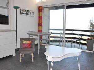 uma sala de estar com uma mesa e uma cadeira em Appartement Perros-Guirec, 1 pièce, 4 personnes - FR-1-368-75 em Perros-Guirec