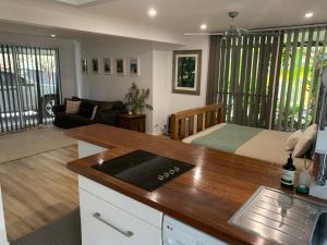 a kitchen and living room with a bed in a room at The Hideaway Jervis Bay in Vincentia