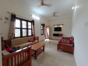 a living room with a couch and a table at NISARGA HOMESTAY, Dharmasthala in Dharmastala