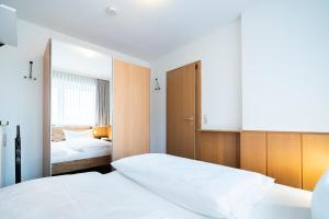 a bedroom with two beds and a mirror at Gorch-Fock-Park App 3 in Timmendorfer Strand