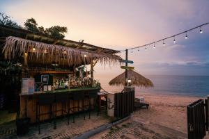 a bar on the beach with a view of the ocean at Mayaana Beach Resort Pattaya - Formerly Golden Tulip Pattaya Beach Resort in North Pattaya