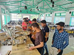 a group of people standing around a table with food at LaSerene The Cottage - Pangot in Nainital +41 photos