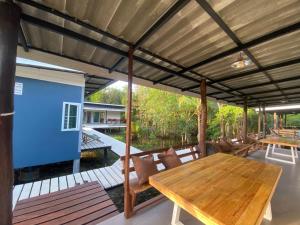 an outdoor patio with a wooden table and chairs at PD Guesthouse in Ko Kood