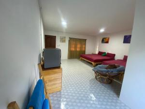 a living room with a tv and a couch at PD Guesthouse in Ko Kood