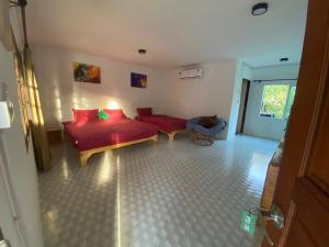 sala de estar con cama roja y sofá en PD Guesthouse en Ko Kood