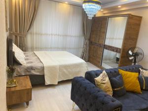 pokój hotelowy z łóżkiem i kanapą w obiekcie L'élégance de JJM w mieście Esenyurt