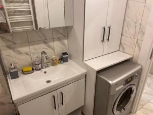 a bathroom with a sink and a washing machine at L'élégance de JJM in Esenyurt