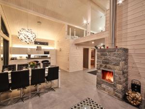 a kitchen and dining room with a stone fireplace at Villa Polaris in Sappee