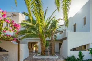 a courtyard with palm trees in front of a building at Okeanis Mystique South in Ierápetra