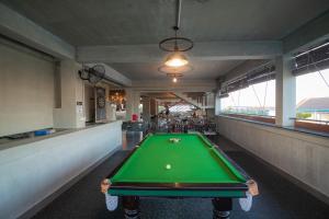 a green pool table in a room with a ball on it at Pooltop Phnom Penh in Phnom Penh