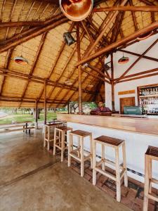 Mangochi的住宿－The Makokola Retreat，酒吧,有木凳,有人坐在酒吧