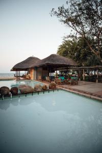 a swimming pool with a house and a resort at The Makokola Retreat in Mponda